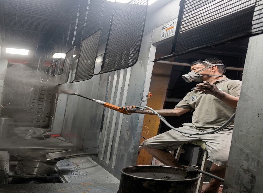 BEVIS finishing technician applying coating to metal display components